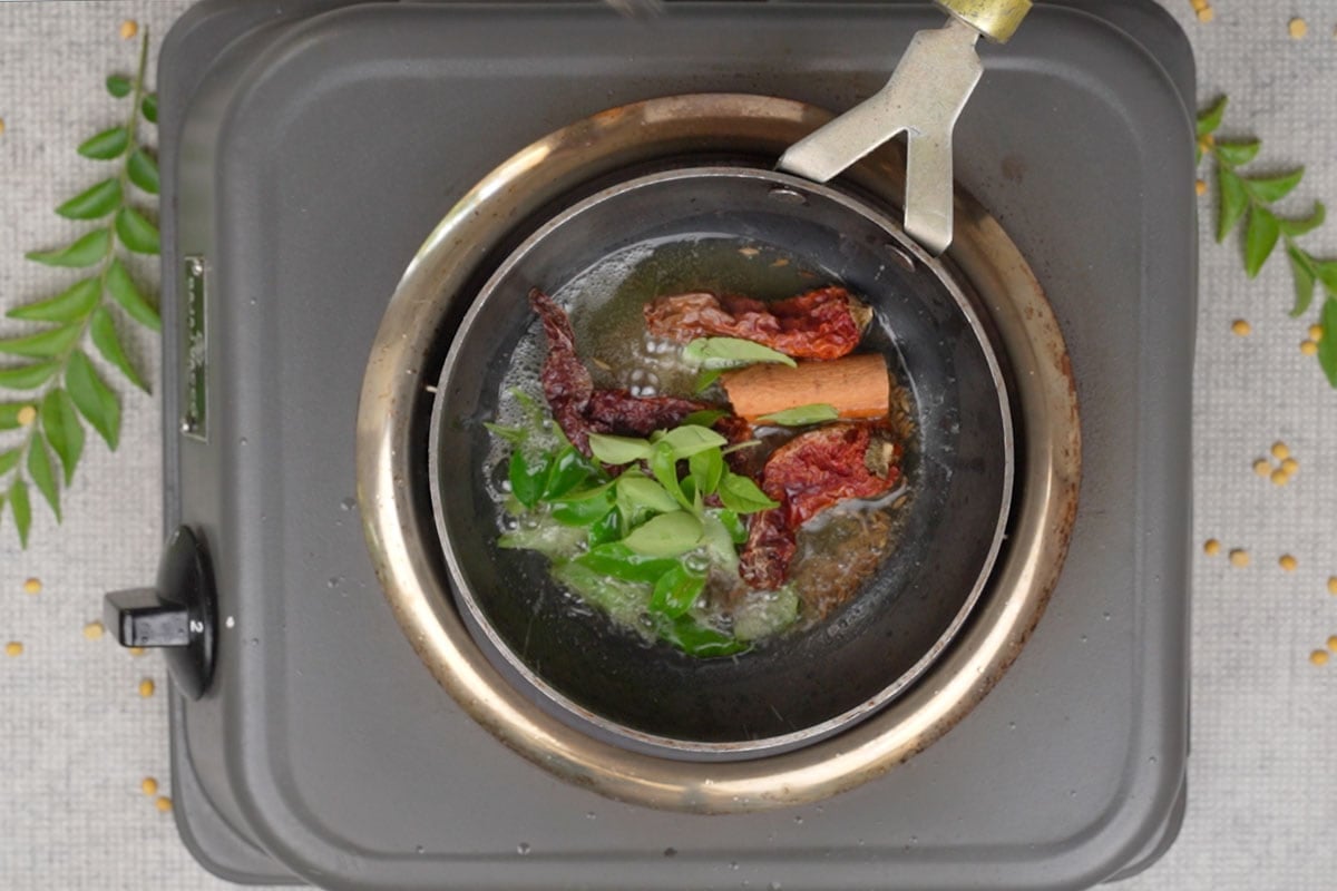 Dry red chilies, cloves, cinnamon and curry leaves added to the pan.