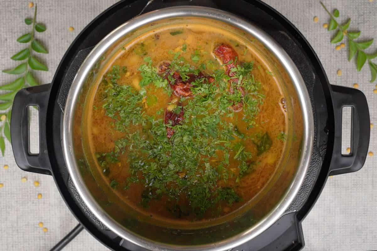 Tempering poured over ready Gujarati dal. Dal garnished with chopped cilantro.