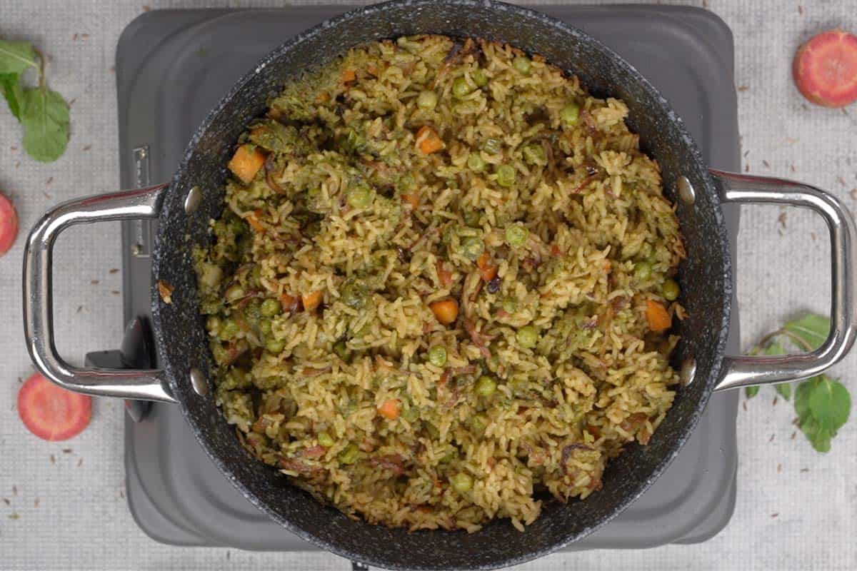 Ready pudina rice fluffed with a fork.