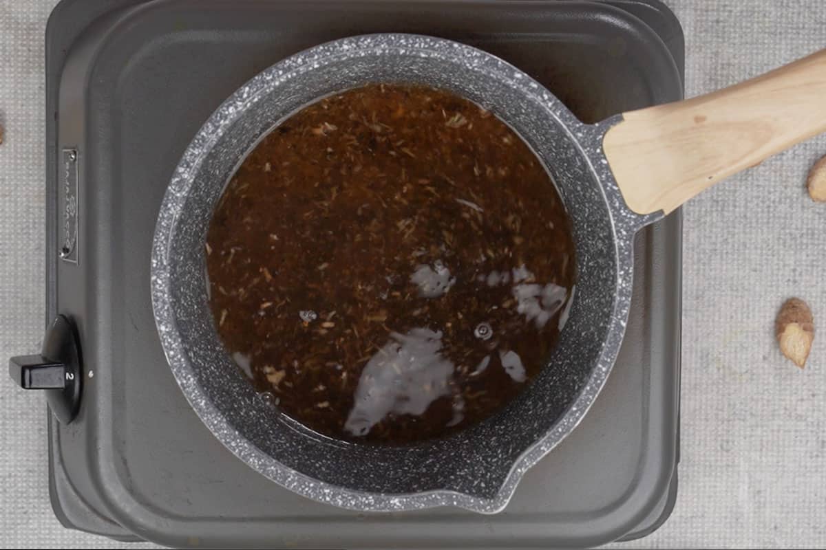 Tea leaves and sugar added to the pan.
