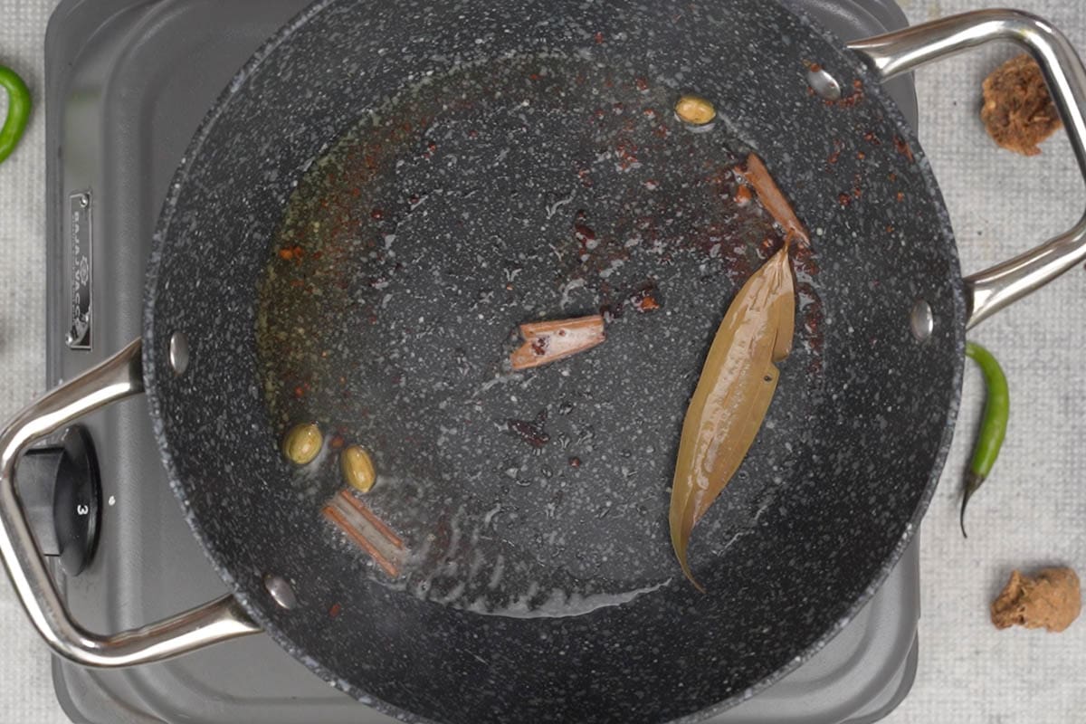 Whole spices added to hot ghee in the pan.