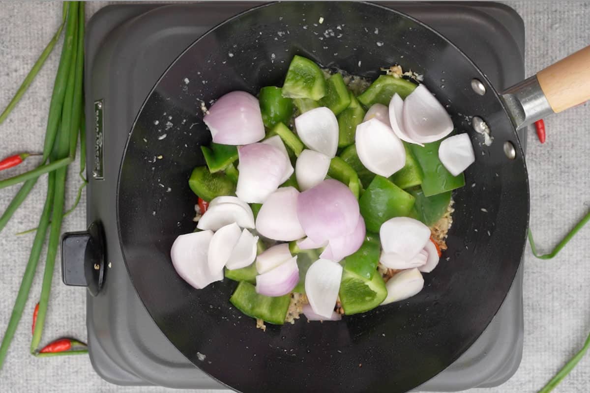 Bell pepper and onion added to the wok.