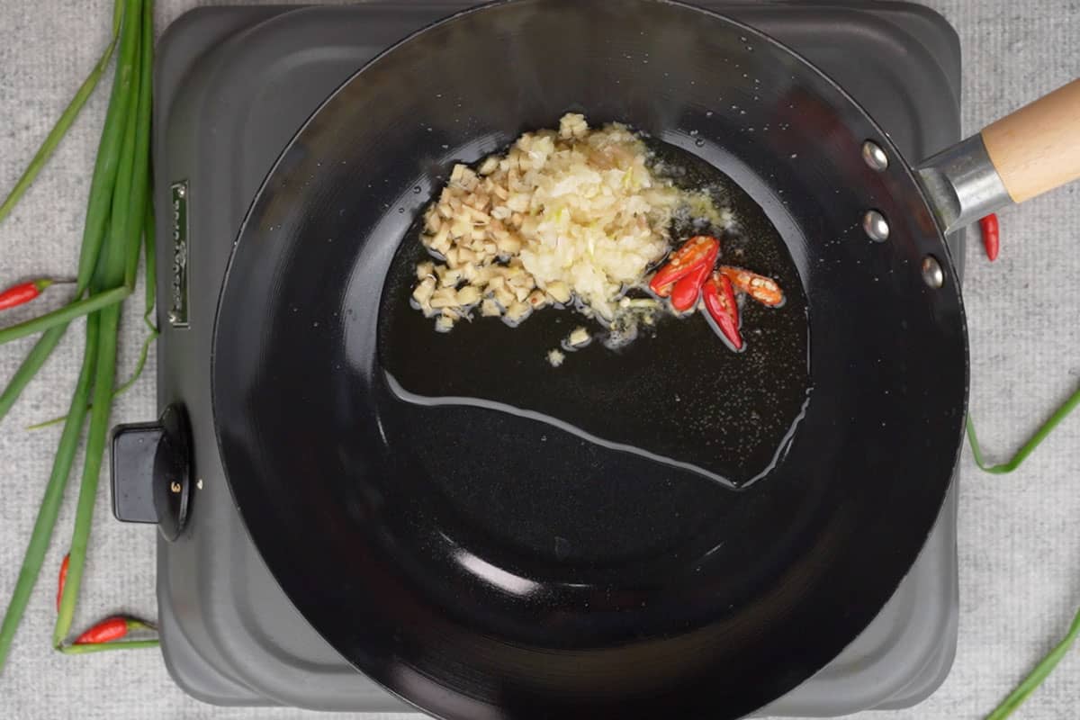 Garlic, ginger and red chilies added to the hot oil.