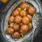 Gulab Jamun are classic Indian dessert which is enjoyed by everyone. These are delectably sweet balls delicately flavored with rose water and dunked in sugar syrup.