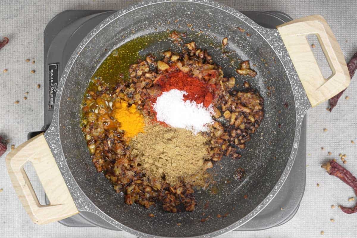 Spice powders added to the pan.