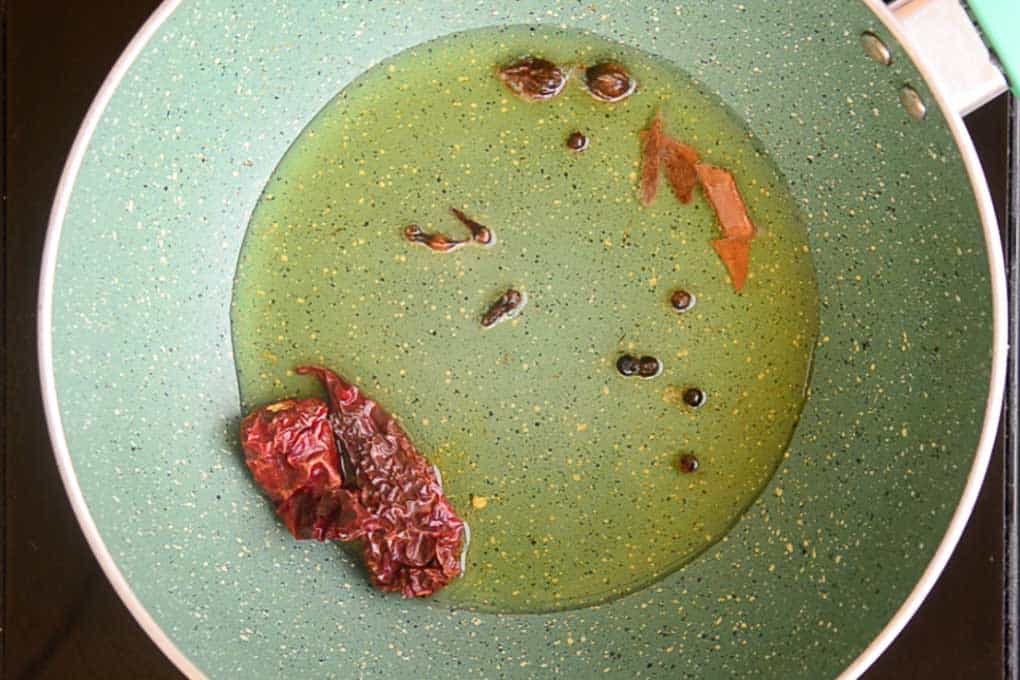 Dry red chillies and whole garam masala in the heated oil in the pan
