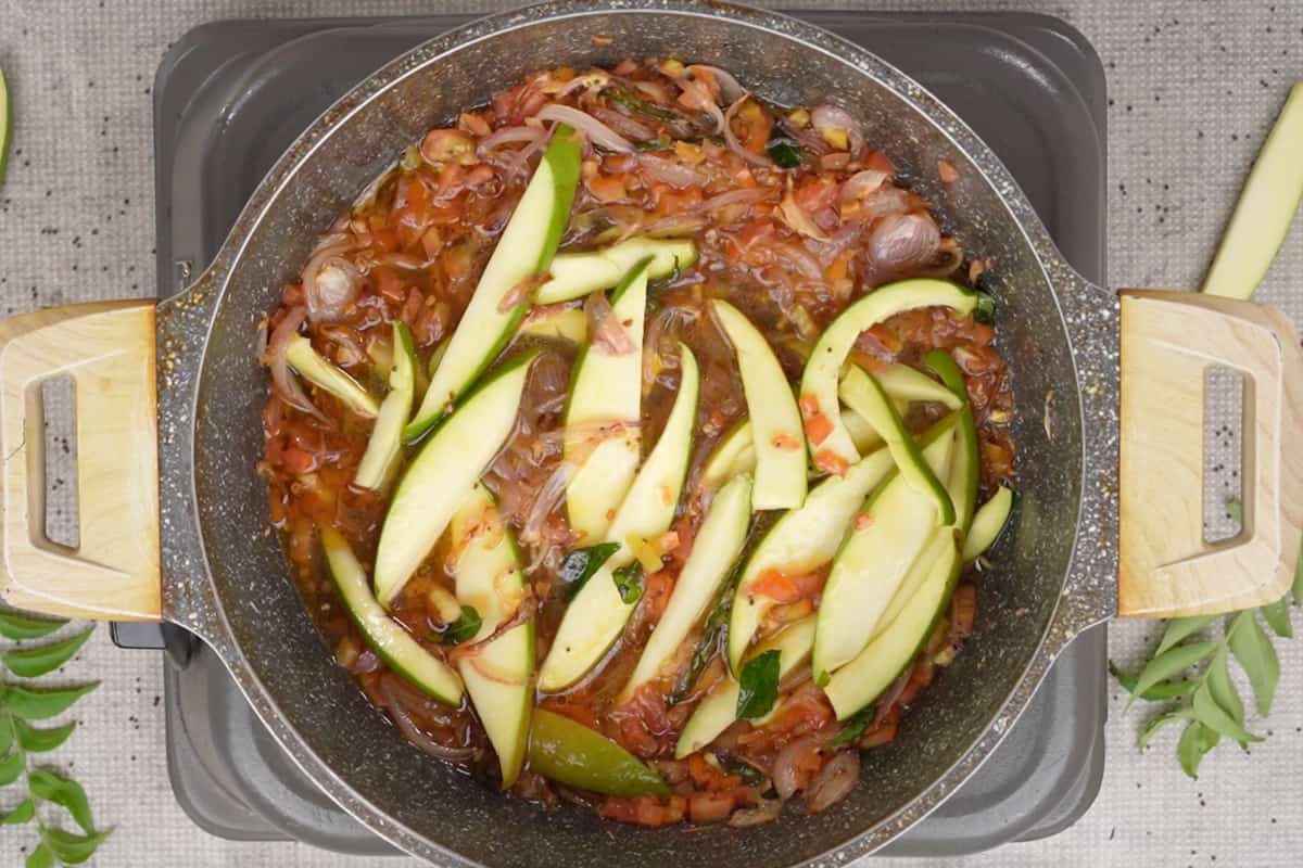 Raw mango and water added to the pan.