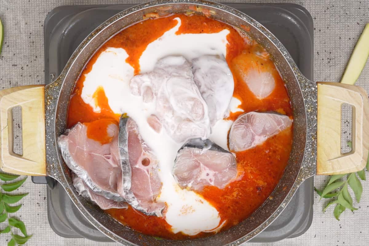Fish slices, water and coconut milk added to the pan.
