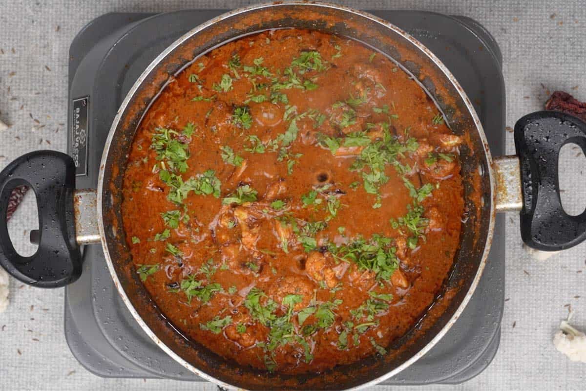 Ready achari gobhi garnished with cilantro.