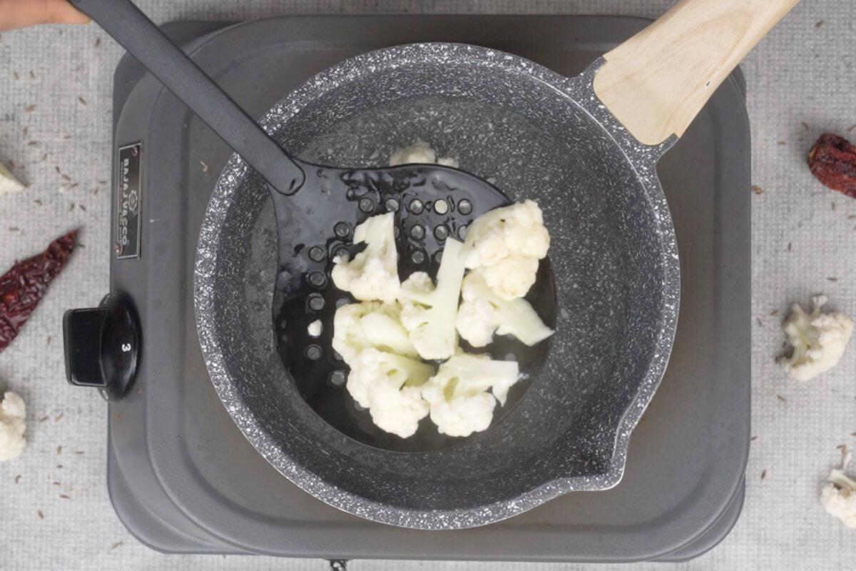 Draining the blanched gobhi.