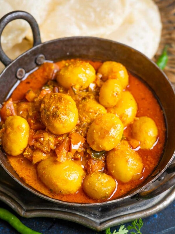 Bengali Aloo Dum (Alur Dom, Aloor Dum) is a potato curry with fried baby potatoes simmered in spicy onion, tomato, and yogurt-based gravy. Make it using my traditional recipe.