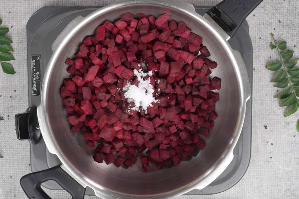 Beetroot, salt and water added to a pressure cooker.