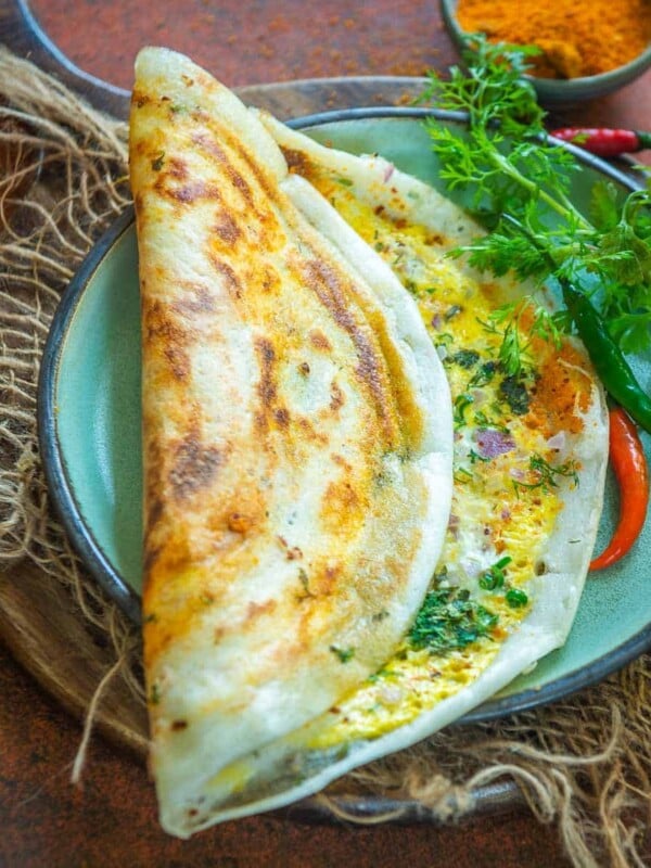 Egg Dosa (Mutta Dosa) is a popular South Indian dish with traditional dosa topped with eggs and spices. It comes together in 10 minutes and makes for a great breakfast or snack. Make it using my easy recipe.