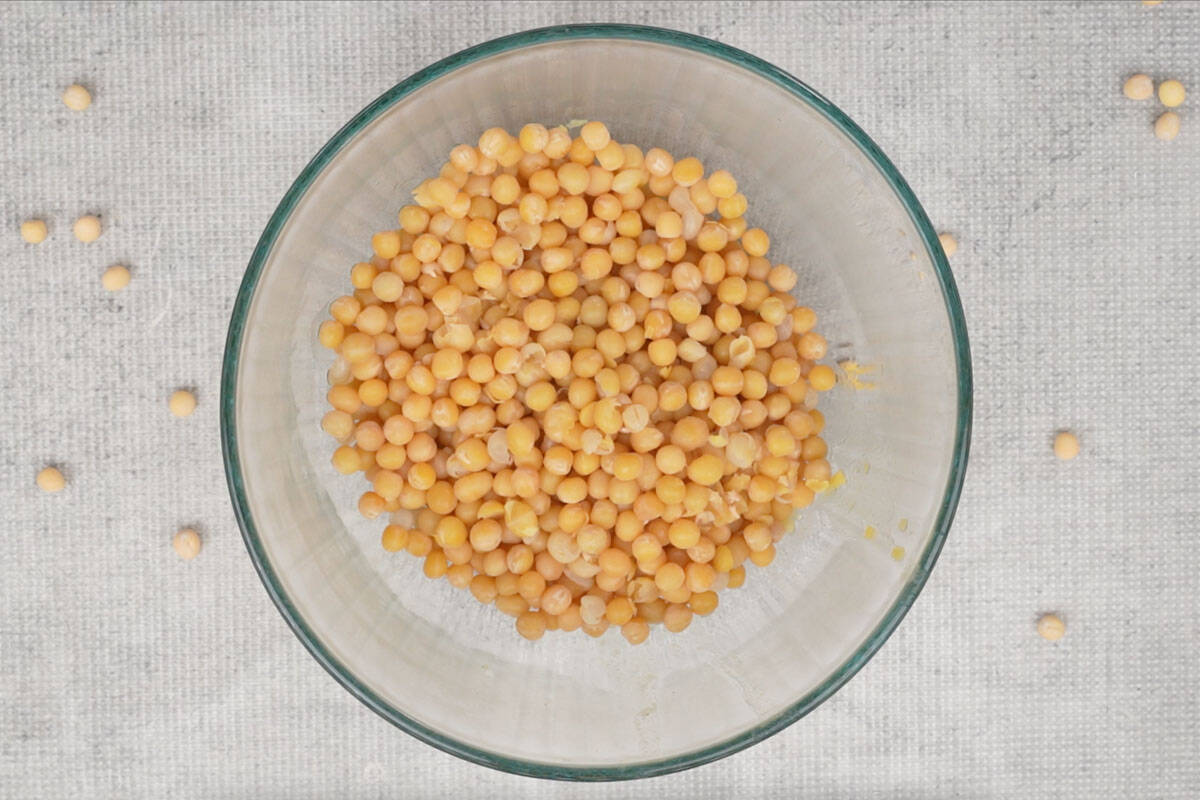 Cooked peas strained and added to a bowl.