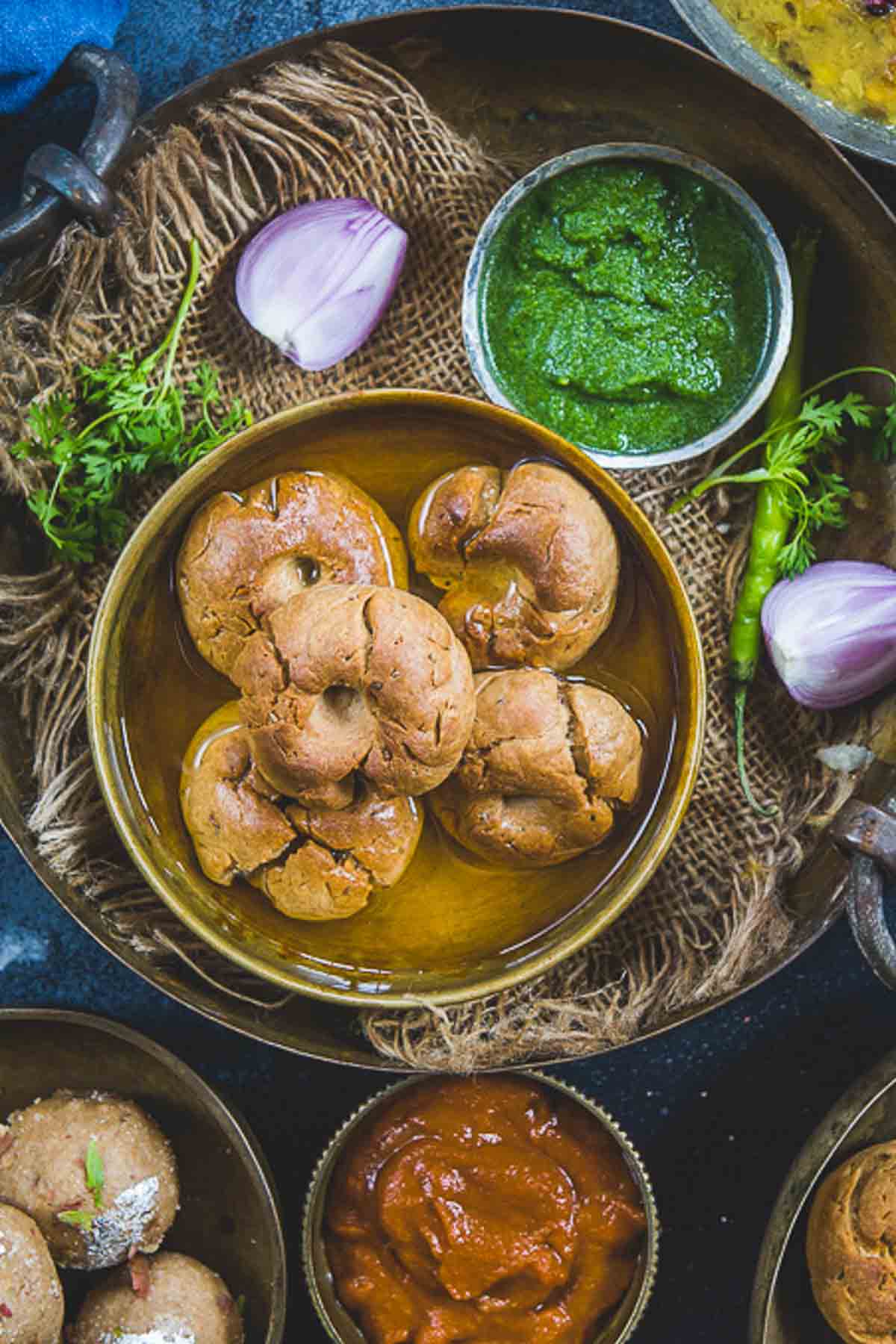 Rajasthani baati served in a bowl with ghee.