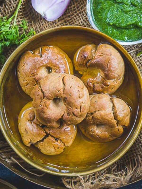 Baati is a traditional Rajasthani bread made using whole wheat flour. It is served with dal, churma, and loads of ghee. Use my easy recipe to make it.