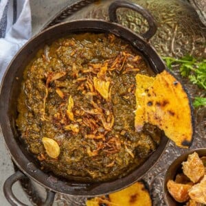 Sarson Ka Saag is a traditional Punjabi dish made with Mustard Greens and other leafy vegetables and a delicious tempering of onion and garlic in ghee. Served with a dollop of White Butter (Makkhan) and crispy warm Makki Ki Roti, this dish is soul-warming.