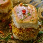 Kutchi Dabeli is a popular Indian Street Food from the state of Gujarat and it's basically pav stuffed with tangy and spicy potato masala and chutneys. Here is how to make it at home.
