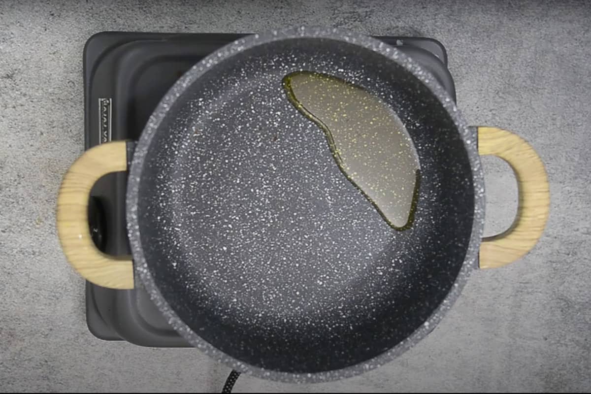 Olive oil heating in a pan.
