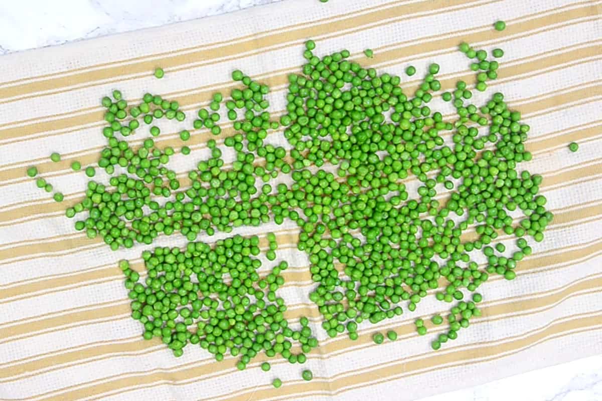 Peas spread on a kitchen towel.
