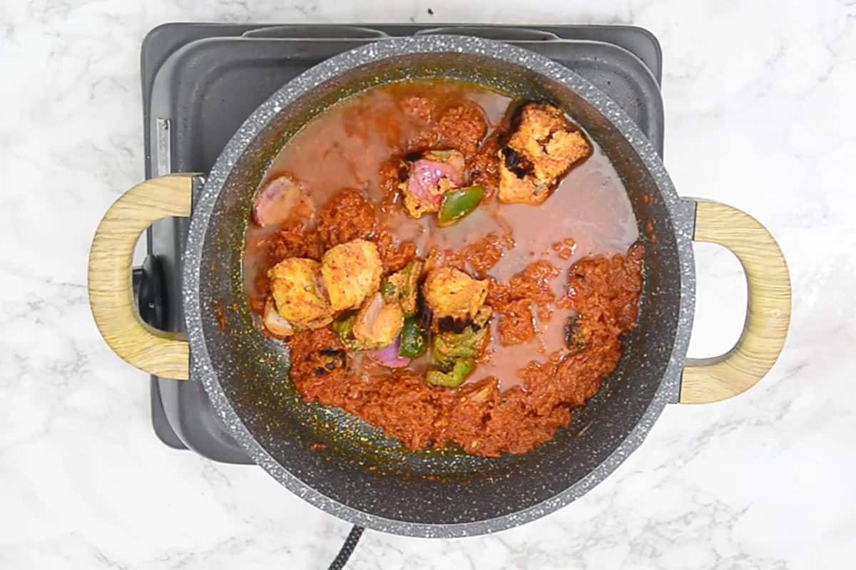 Water and grilled paneer and veggies added in the pan.