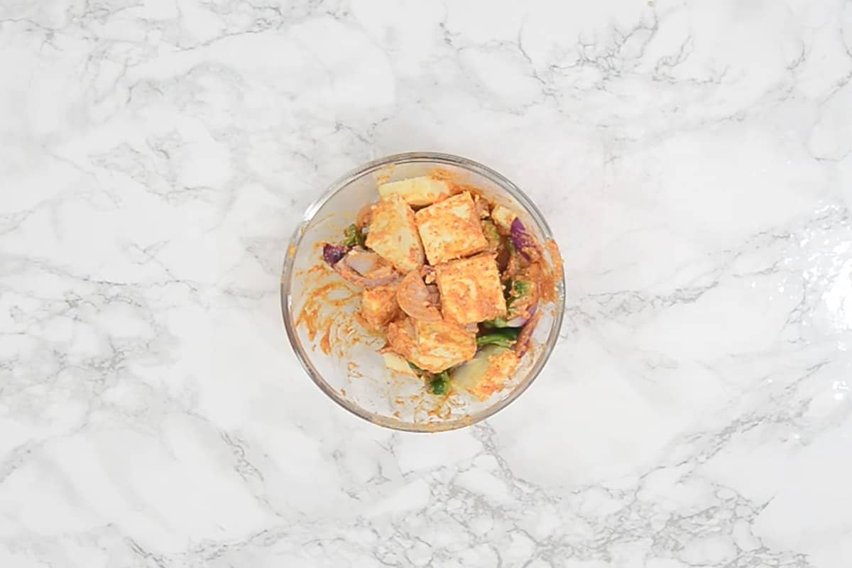 Paneer cubes, onion and capsicum mixed with the marinade.
