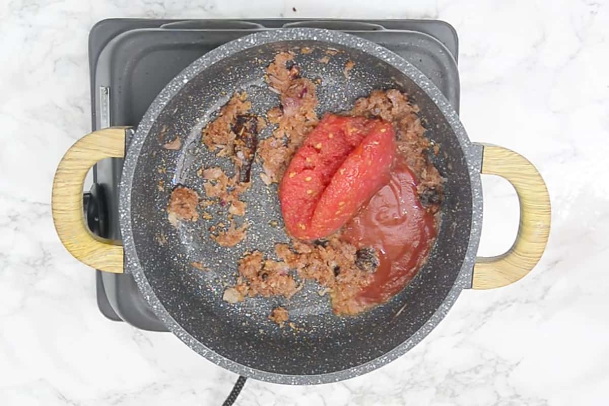 Grated tomato and tomato puree added in the pan.