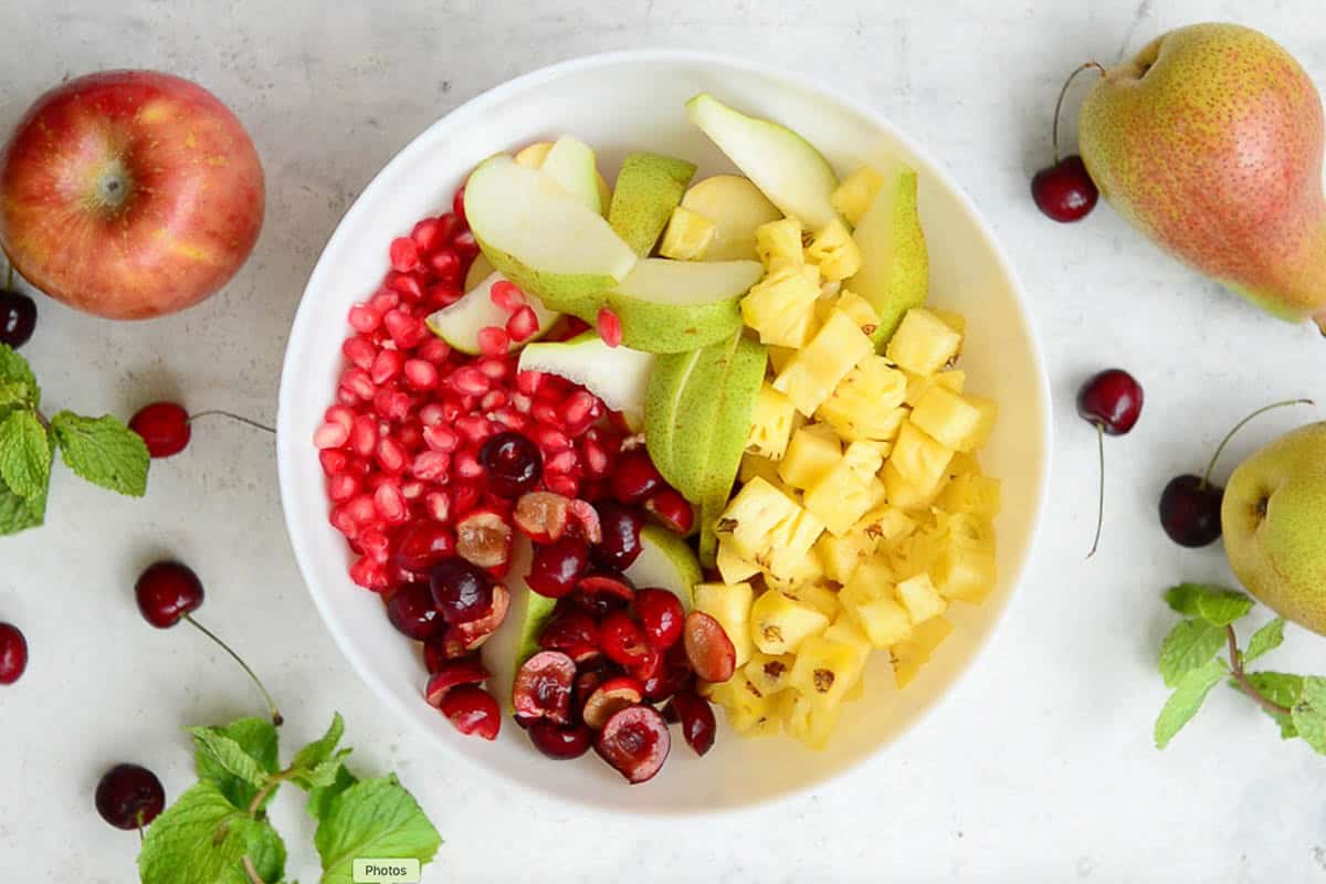 Fruits mixed with lemon juice in a bowl.