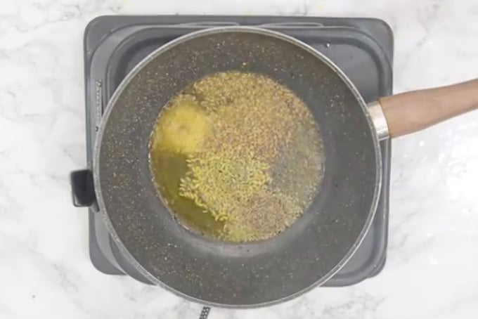Mustard seeds, cumin seeds, hing, fennel seeds and carom seeds added in oil.