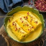 Bread Malai Roll is an Indian sweet where white bread slices are stuffed with a thick rabdi and then dunked in flavourful reduced milk. Here is how to make it.