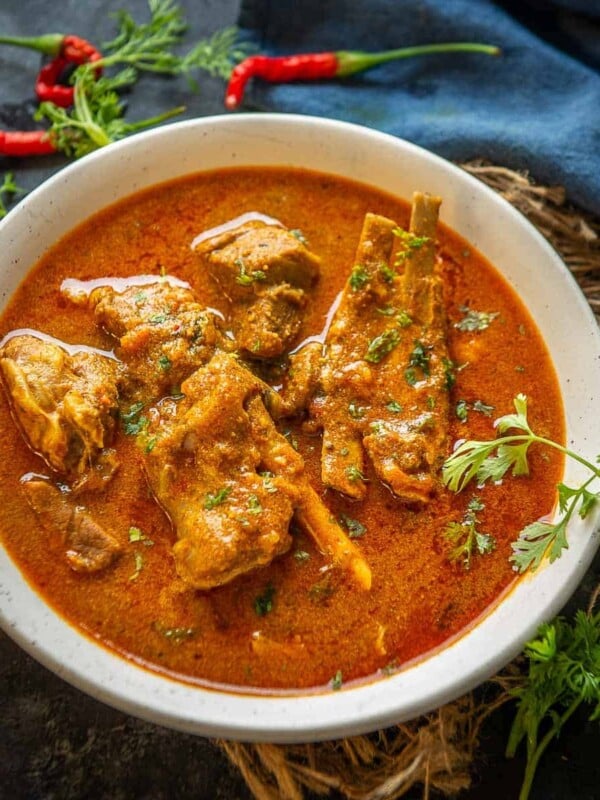 Mutton Kulambu Curry (Mutton Kuzhambu) is a spicy village-style mutton curry famous in India's Chettinad region. It can be made in a traditional stovetop pressure cooker or instant pot.