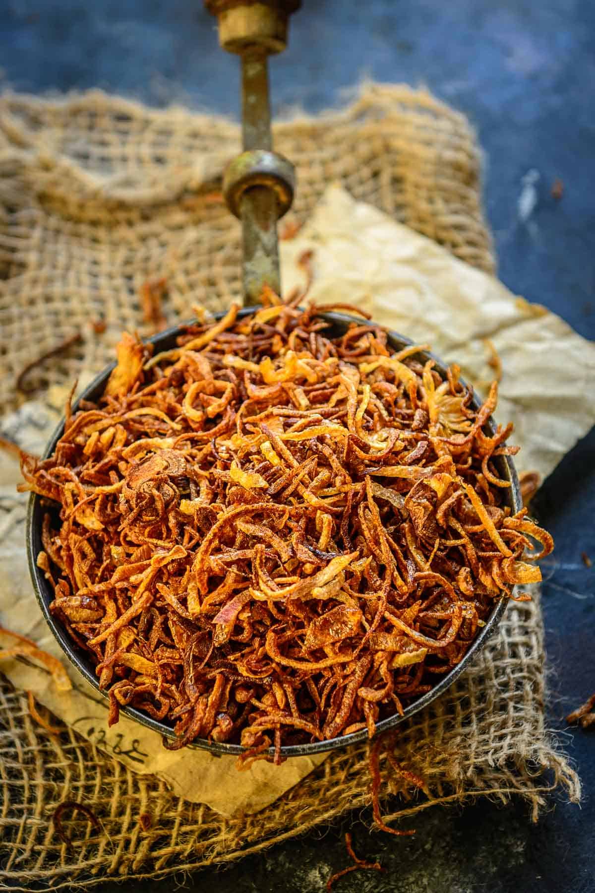 Crispy fried onions (birista) kept in a bowl.