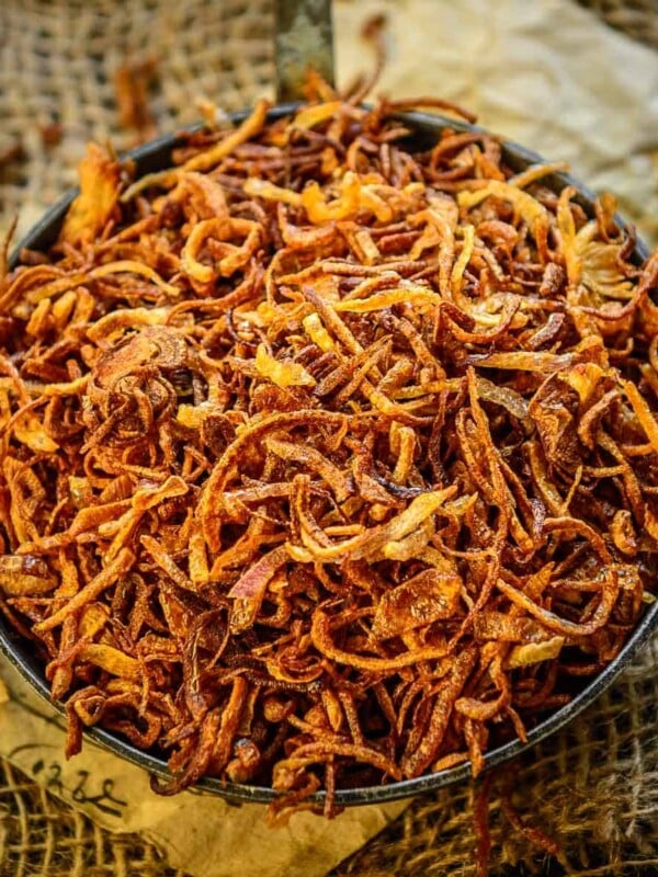 Birista (Crispy Fried Onions) are thinly sliced onions deep-fried in oil until golden brown and crisp. They are used to make curries, biryani, soups, and dals. Make them perfectly using my easy recipe.