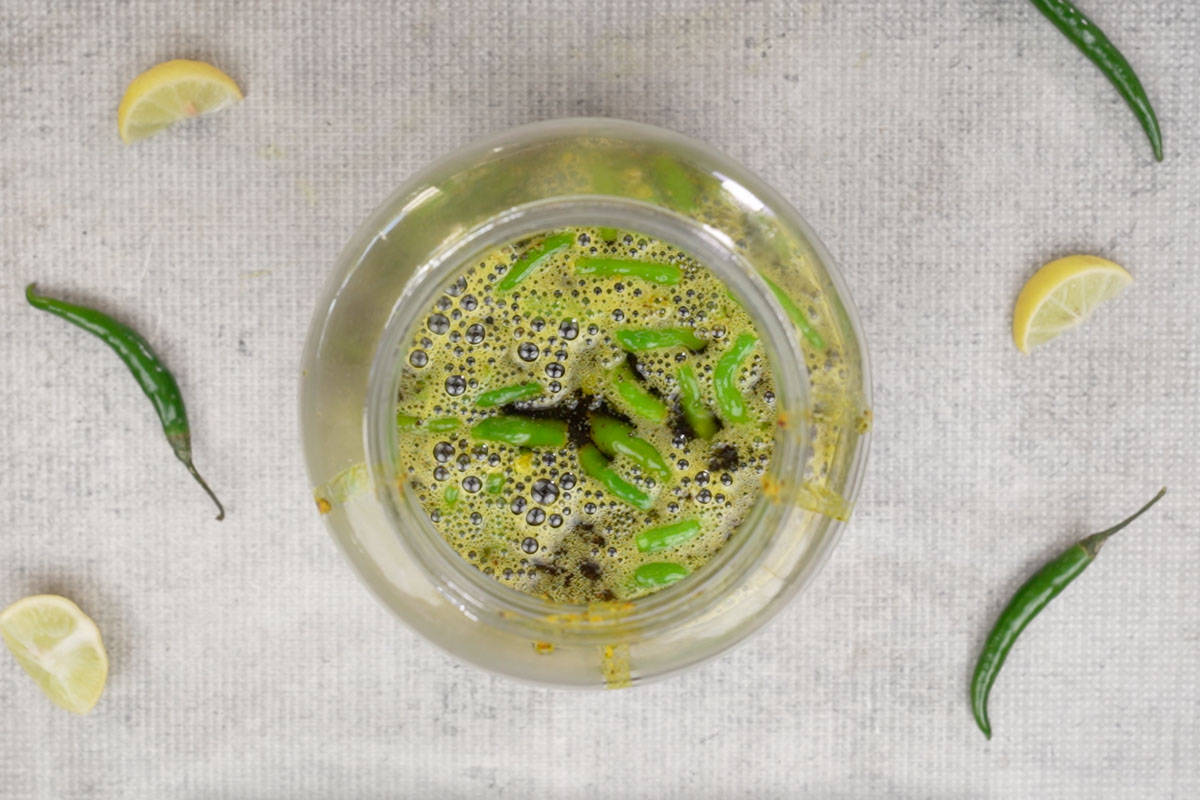 Oil poured over the green chilli pickle.