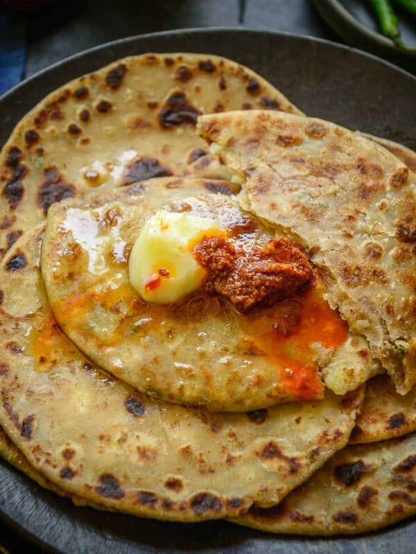 Aloo paratha is an Indian unleavened whole wheat flatbread stuffed with a spicy and super flavorful potato filling. It is one of the most popular breakfasts and is best enjoyed with plain yogurt, butter, and pickle. Check out my easy recipe with lots of variations, tips, and tricks.