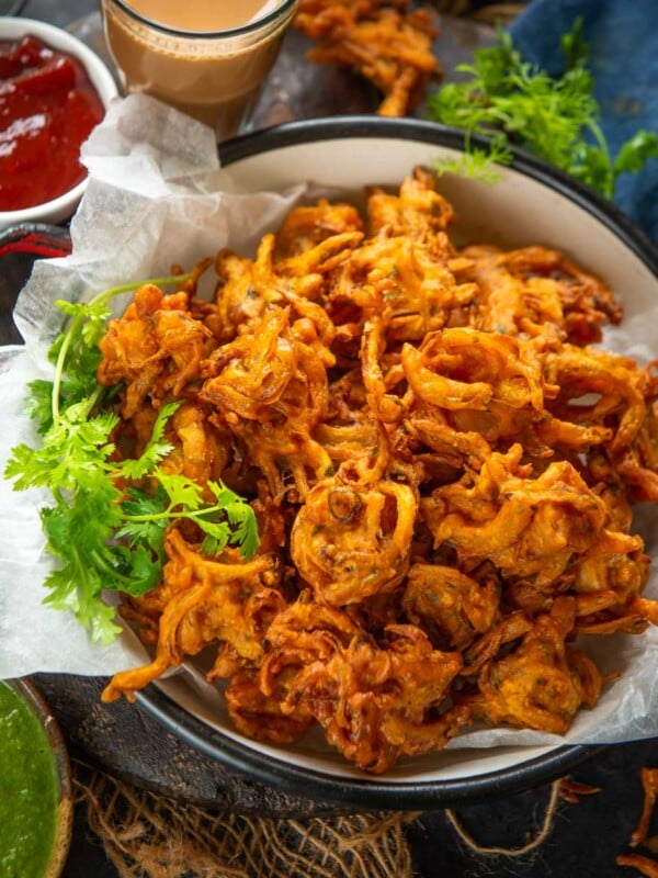 Crispy Onion Pakoda (Onion Pakora, Kanda Bhaji, Indian Onion Fritters) is one of the favorite Indian snacks during the monsoons or winter days. Make the best onion pakora using my easy recipe (vegan, can be easily made gluten-free).
