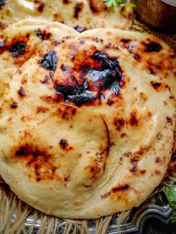 Make restaurant-style Tandoori Roti at home using my easy recipe. This Indian bread is soft in the center and crisp at the edges and it is traditionally made in clay ovens (tandoor). You can make it at home on a tawa over the stovetop or in an oven.