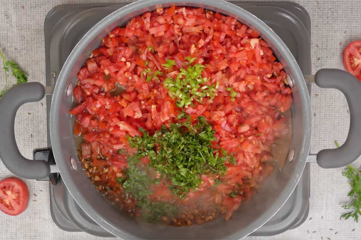 Tomato, cilantro and chilies added to the pan.