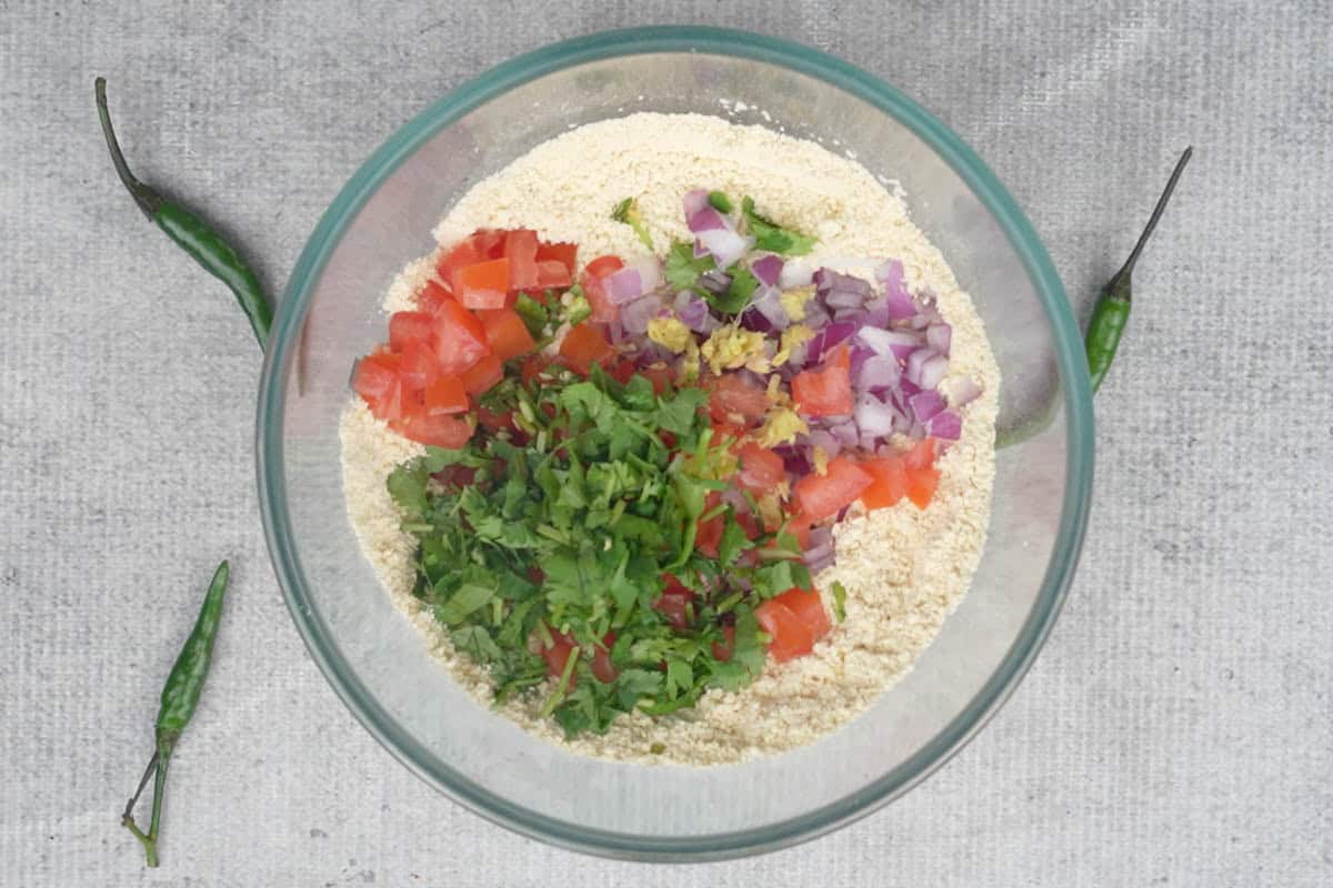 Onions, tomatoes, green chilies, ginger and cilantro added to the bowl.