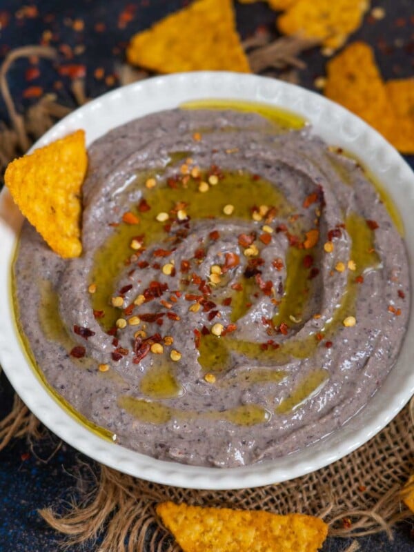 This creamy Black Bean Hummus is a delicious take on classic hummus where black beans are used instead of chickpeas. This vegan and gluten-free dip is a party favorite and can be served with tortilla chips, veggie sticks, or pita bread.