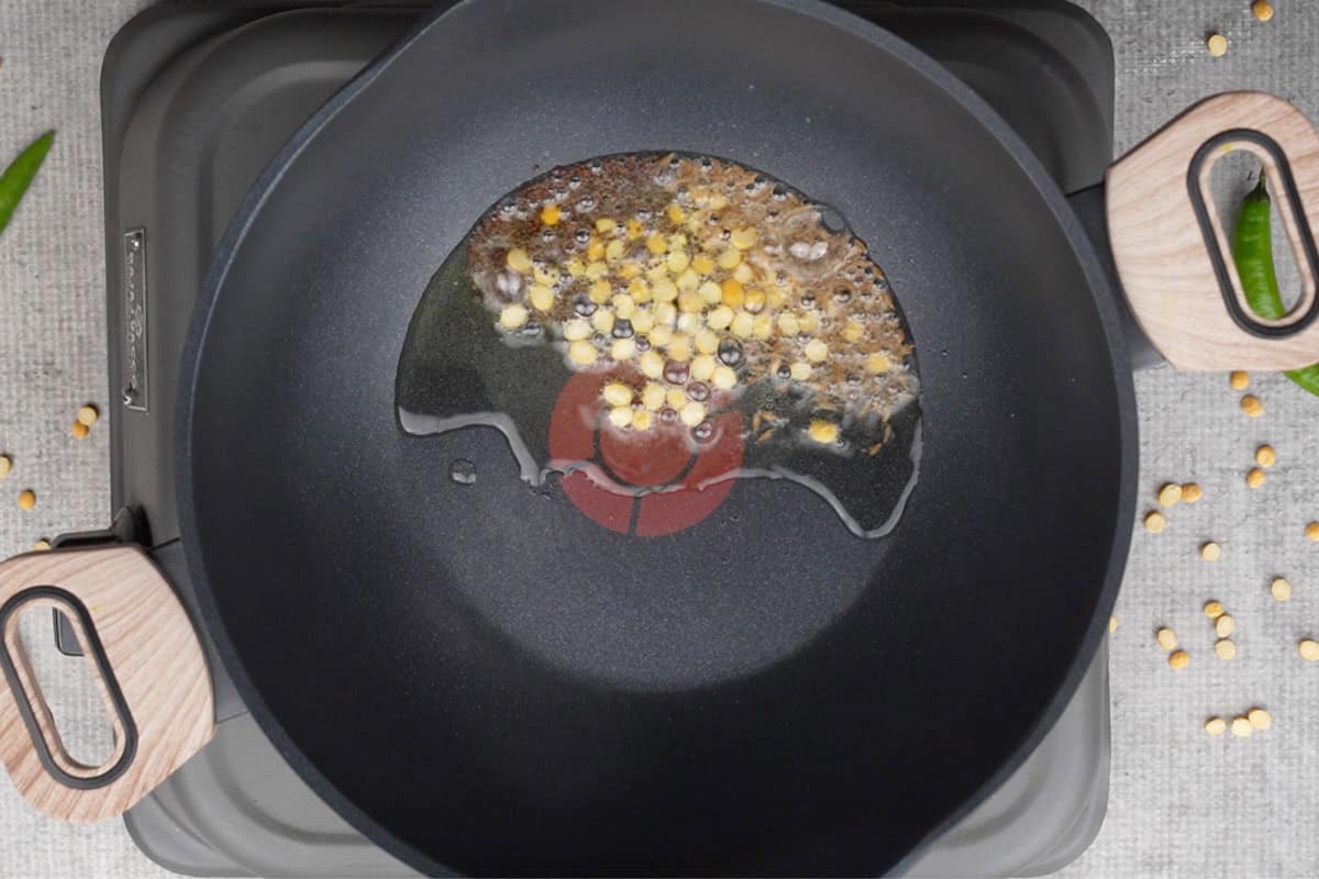 Mustard seeds, cumin seeds and dal added to hot oil in a pan.