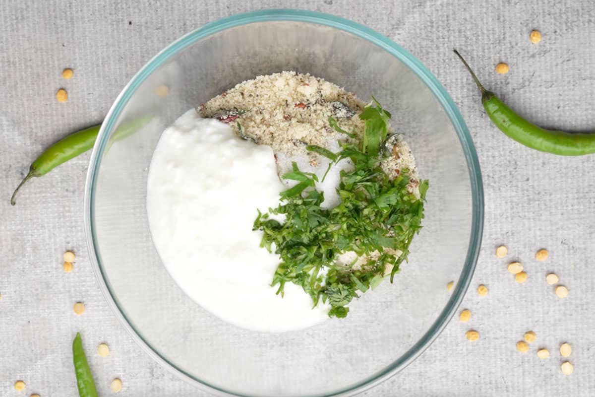 Yogurt, salt, coriander, and water added the bowl.
