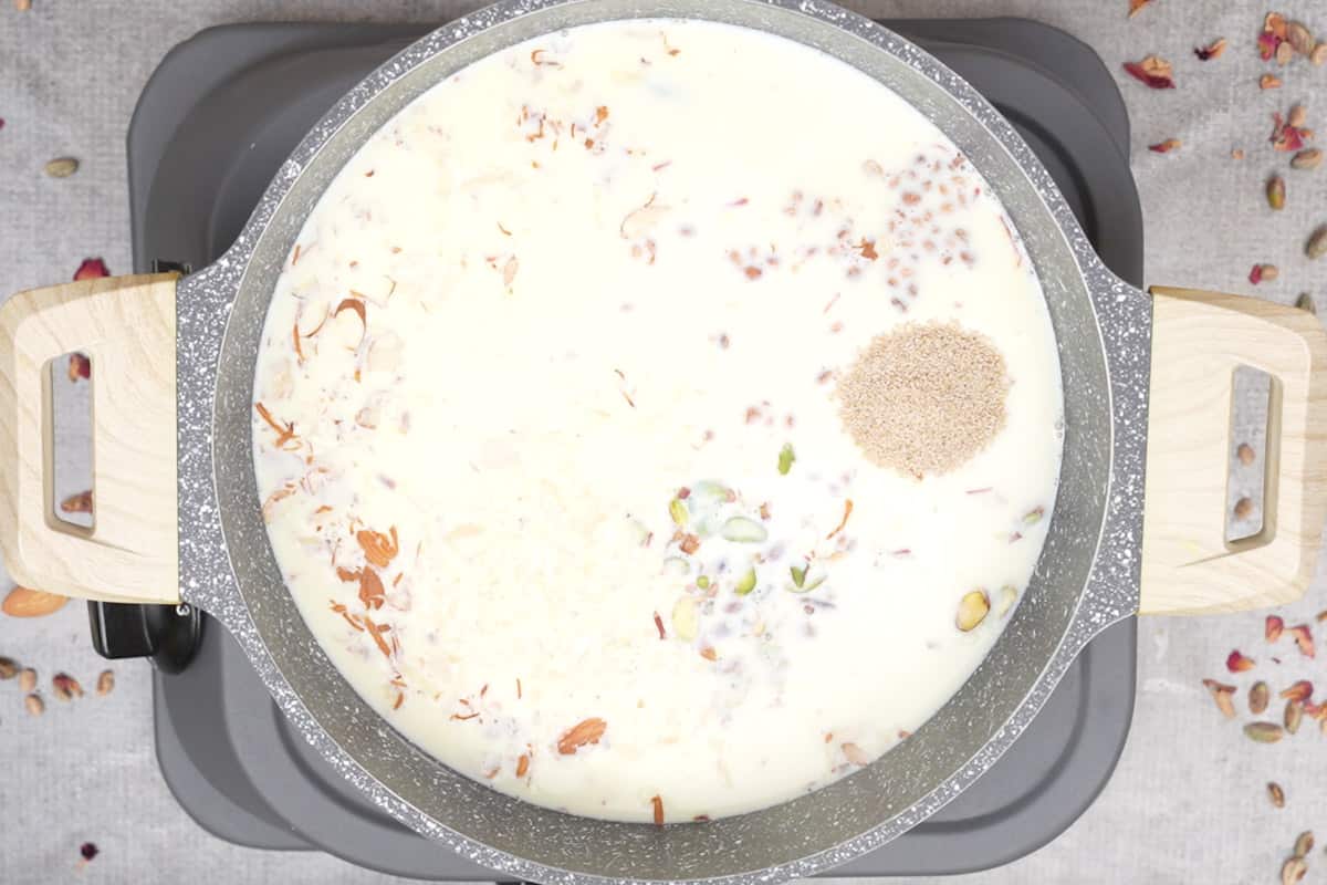 Saffron soaked in milk, nuts, fruits and seeds added to the pan.