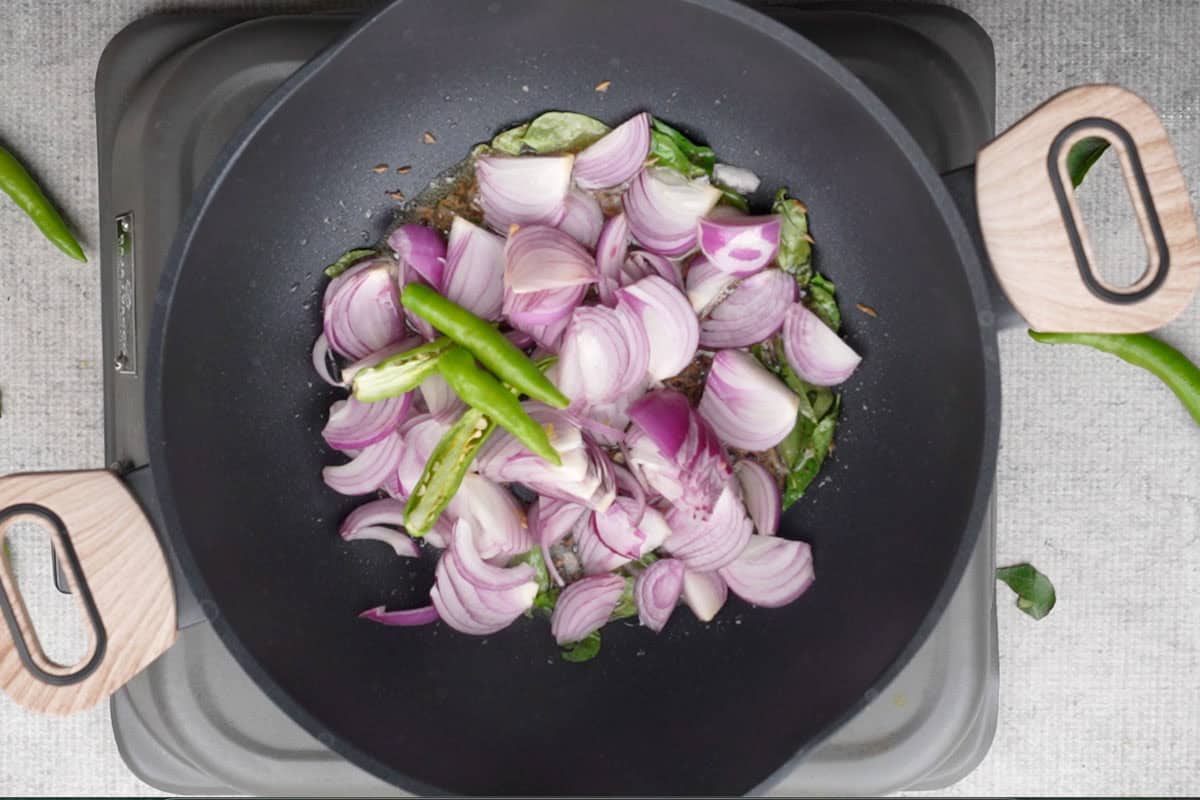 Onion and green chilies added to the pan.