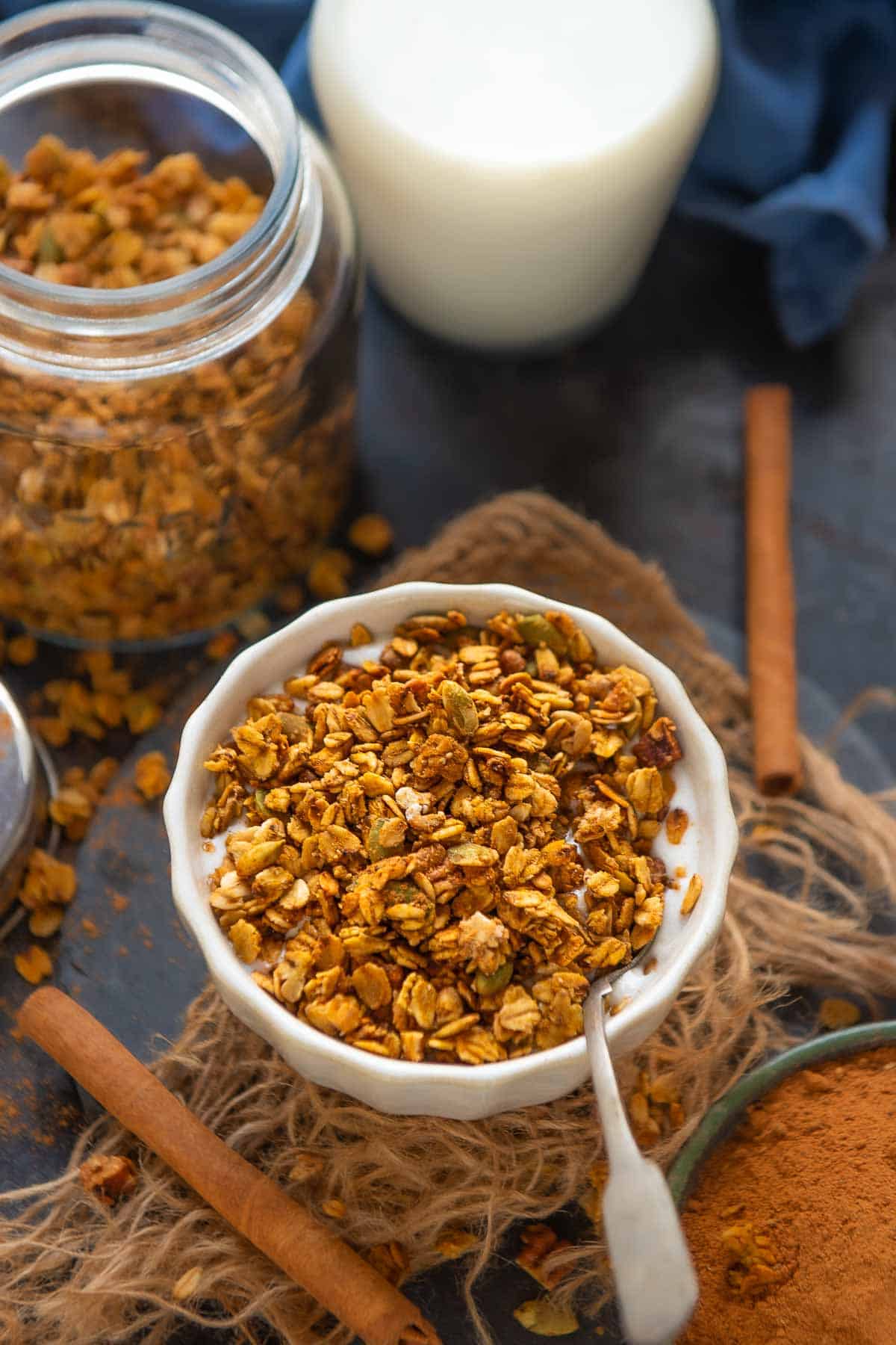 Pumpkin spice granola served in a bowl with milk.