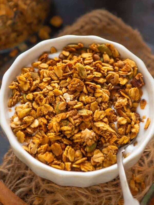 Make this healthy and super easy Pumpkin Spice Granola at home in under 30 minutes using 8 ingredients. It's super crunchy and loaded with fall flavors (vegan).