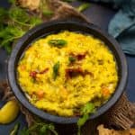 Dalia Khichdi (Broken Wheat Moong Dal Khichdi, Fada ni Khichdi) is a healthy Indian comfort food made with yellow lentils and broken wheat. Here is how to make it.