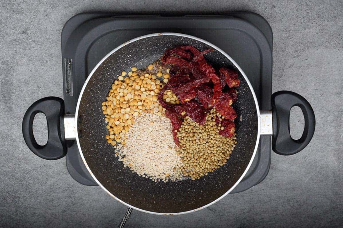 Chana dal, urad dal, dry red chilies and coriander seeds added to the pan.