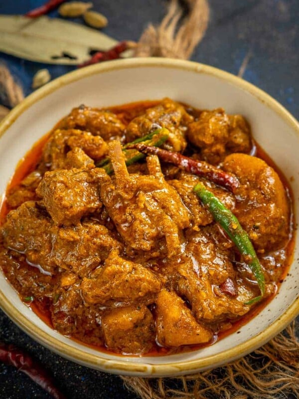 Kosha Mangsho (Mutton Kosha) is a delicious spicy Bengali-style mutton curry that is full of flavors from mutton (goat meat), spices, and mustard oil. Here is how to make it in traditional style.