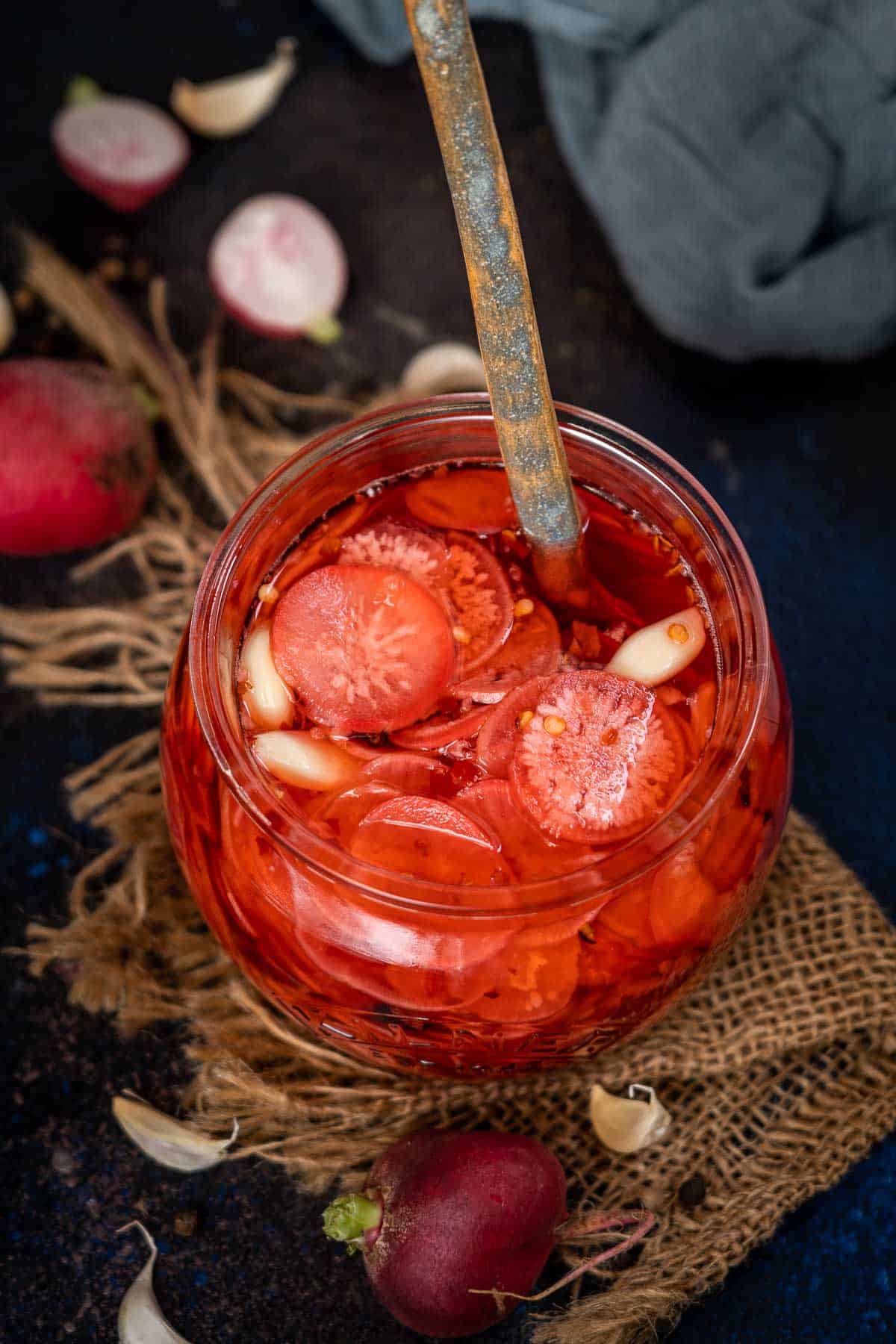 Spicy pickled radishes served in a jar.